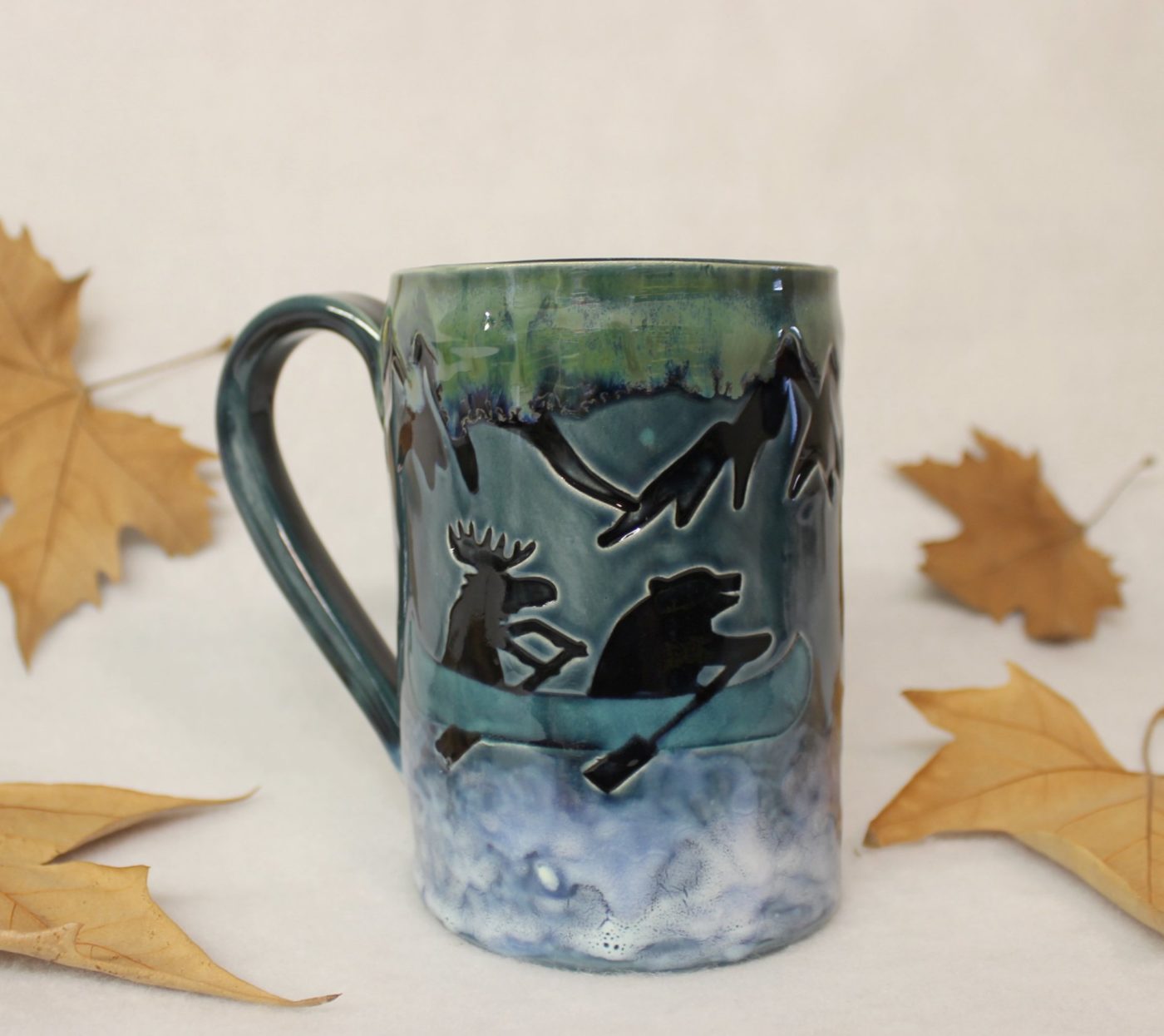 Bear and Moose in a Blue Canoe on a Mountain River Ceramic Mug